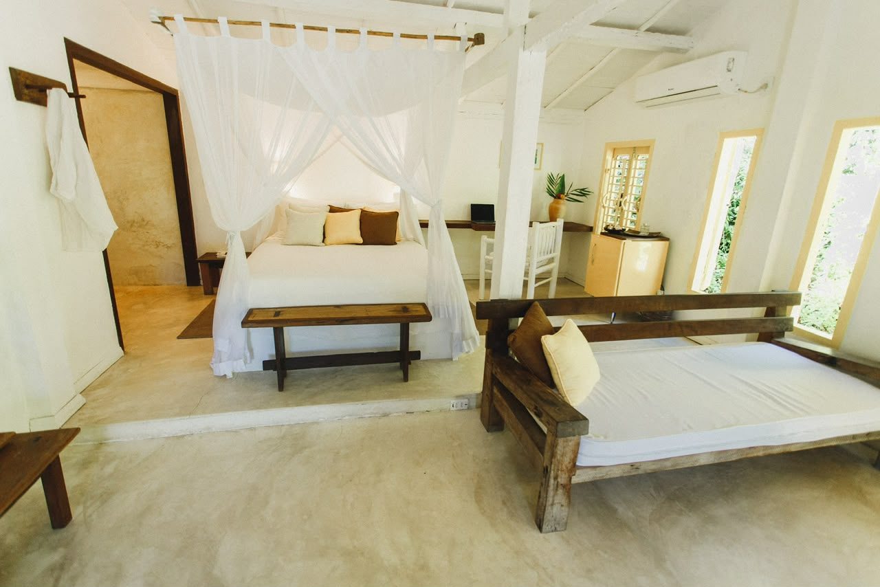 Quarto do Bangalô Amarelo com cama de dossel e sofá-cama de madeira