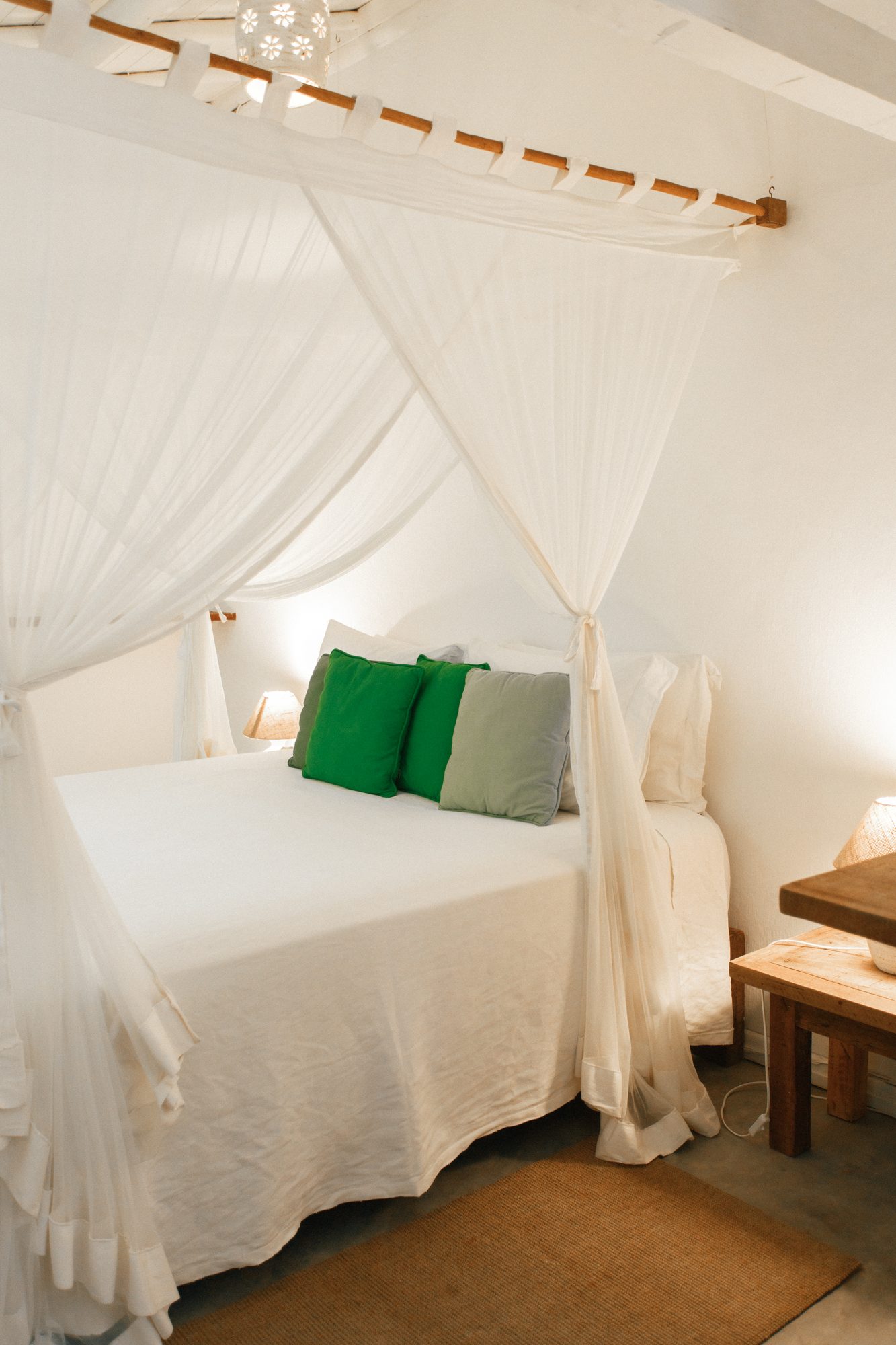 Cama de dossel do Bangalô Branco com almofadas verdes
