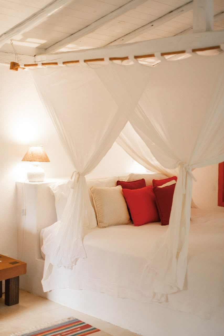 Detalhe do dossel e das almofadas da cama do Bangalô Laranja